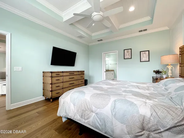 a bedroom with a bed and a flat tv screen on dresser