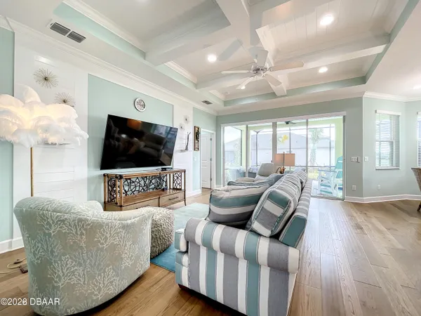 a living room with furniture a flat screen tv and a floor to ceiling window