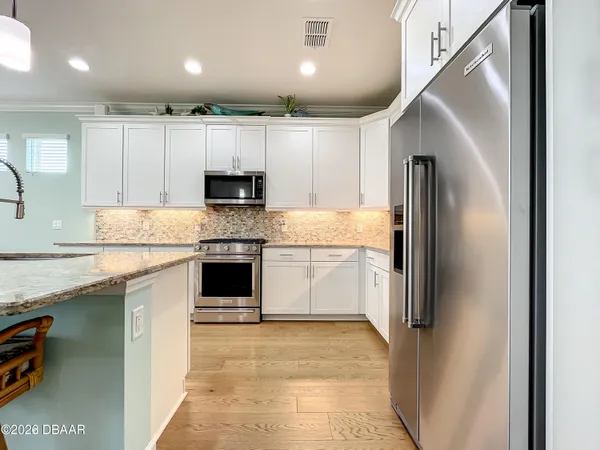 a kitchen with stainless steel appliances kitchen island granite countertop a stove and cabinets