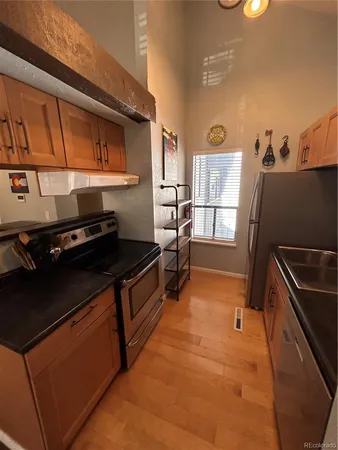 a kitchen with stainless steel appliances granite countertop a refrigerator and a stove