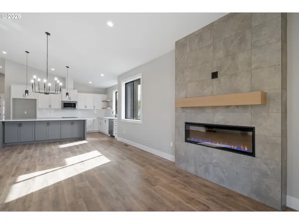 a view of an empty room with a fireplace and window