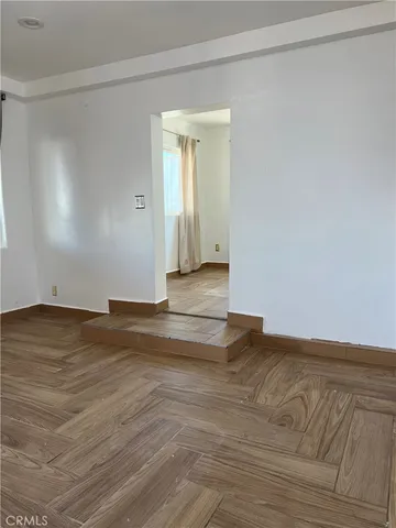a view of empty room with wooden floor and fireplace