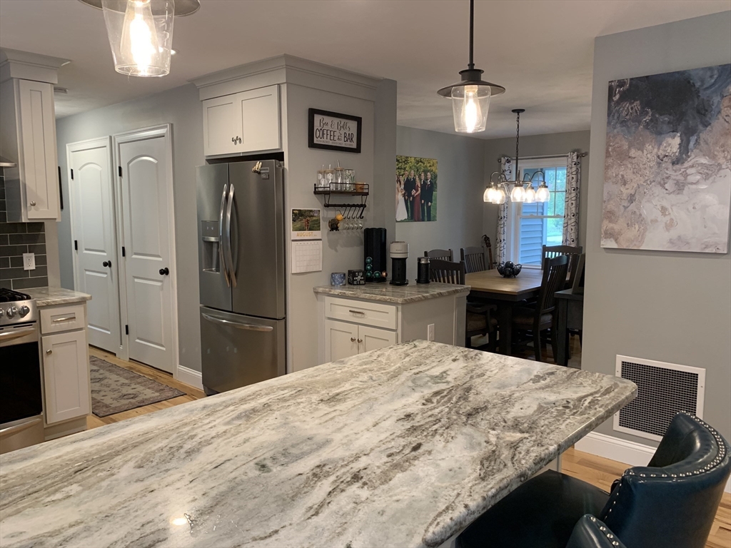 39 Davidson Road Charlton, MA 01507 - Photo 4 of 42 a kitchen with stainless steel appliances kitchen island granite countertop a refrigerator a stove a sink dishwasher with a dining table and chairs