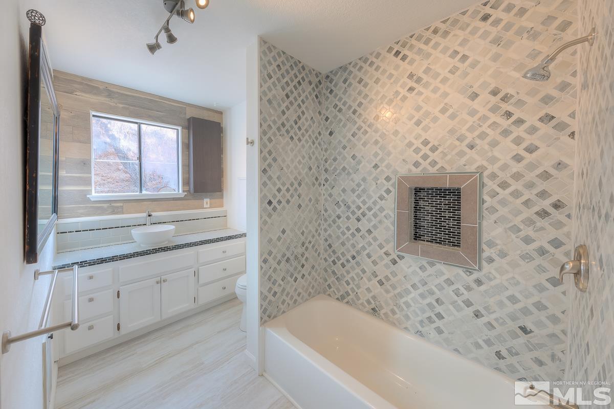 13830 Virginia Foothills Drive Reno, NV 89521 - Photo 18 of 25 a bathroom with a bathtub and a sink