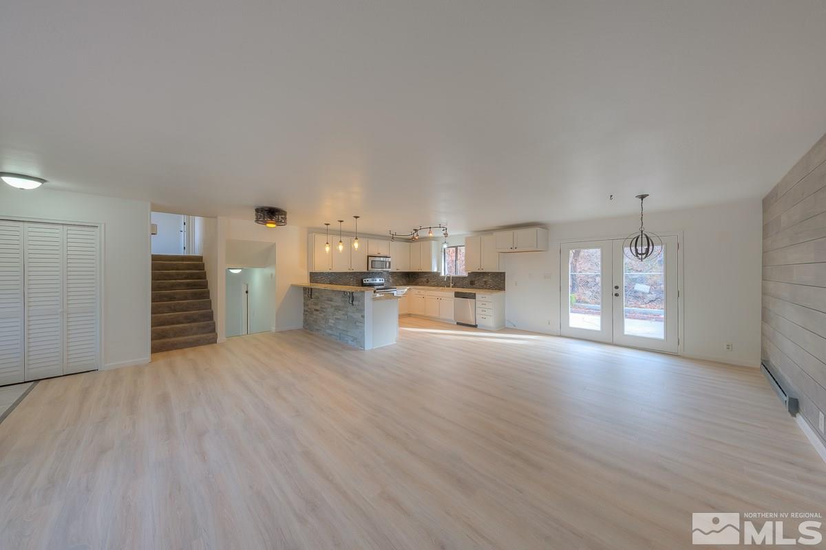 13830 Virginia Foothills Drive Reno, NV 89521 - Photo 5 of 25 a view of empty room with kitchen appliances and wooden floor