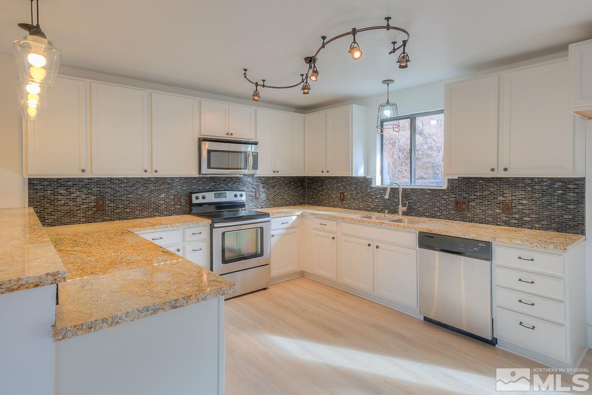 13830 Virginia Foothills Drive Reno, NV 89521 - Photo 6 of 25 a kitchen with granite countertop a stove sink and microwave