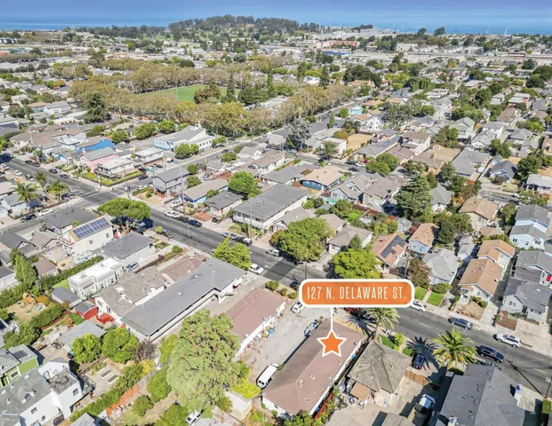 an aerial view of residential houses with yard