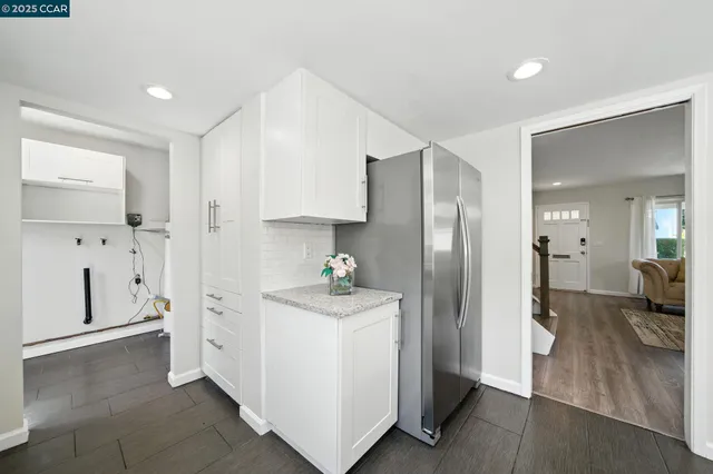 a kitchen with white cabinets and stainless steel appliances