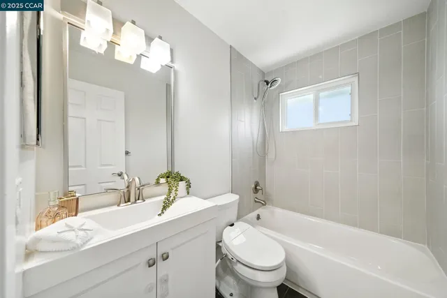 a bathroom with a granite countertop sink a toilet and shower