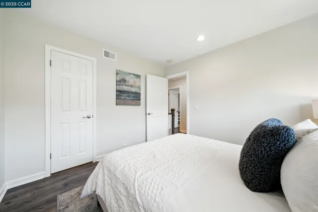 a bedroom with a white bed and a dresser