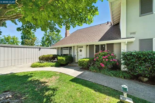 a view of a house with a big yard and potted plants