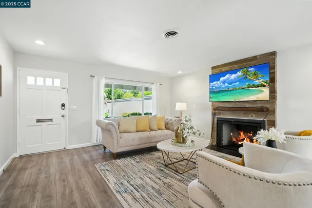 a living room with furniture a fireplace and a flat screen tv