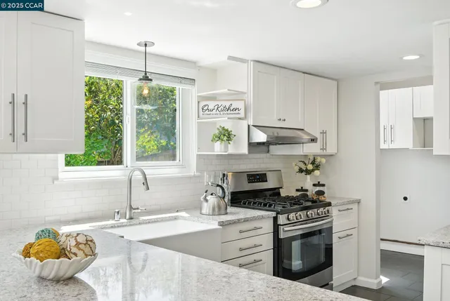 a kitchen with stainless steel appliances granite countertop a sink stove and refrigerator