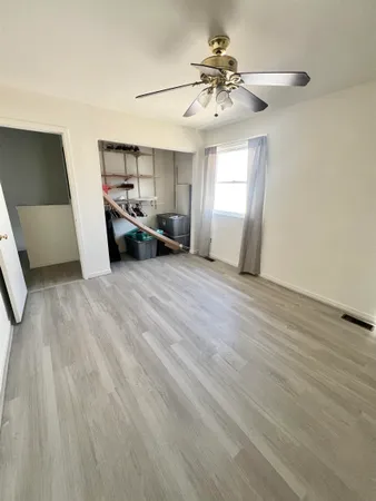 a view of a livingroom with a furniture ceiling fan and window