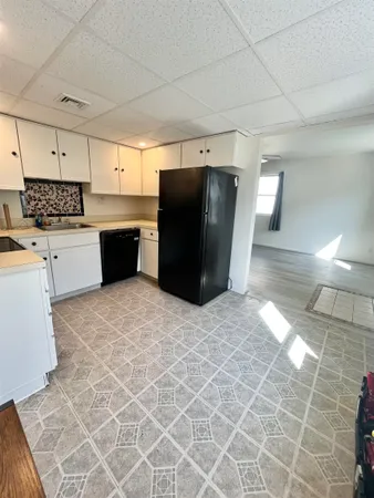 a kitchen with granite countertop a refrigerator and a stove top oven