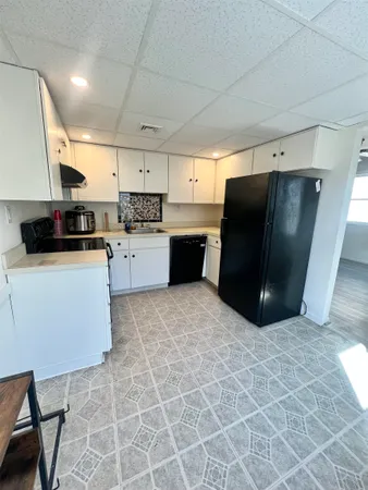 a kitchen with stainless steel appliances granite countertop a refrigerator and a stove top oven