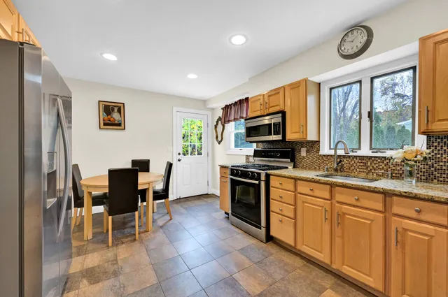 a kitchen with stainless steel appliances granite countertop a stove top oven a sink a counter top space and cabinets