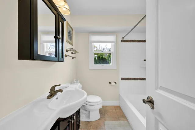 a bathroom with a sink a toilet and a mirror