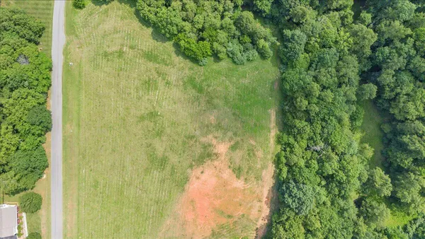 an aerial view of a house with a yard and lake view