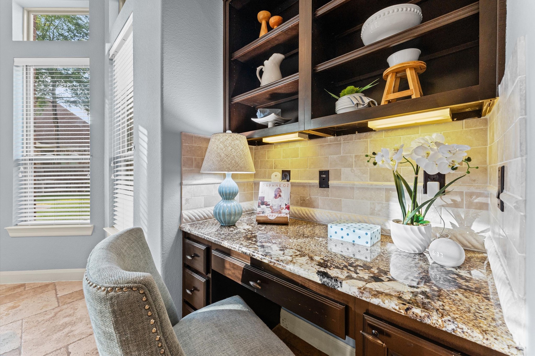 70 Valera Ridge Drive Spring, TX 77389 - Photo 21 of 37 This cozy nook offers a built-in granite desk with ample shelving and soft lighting, perfect for a home office or study space. Large windows bring in natural light, complementing the elegant decor and creating a welcoming atmosphere.