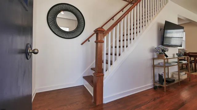 a view of a hallway with wooden floor and staircase