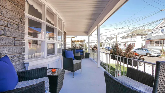 a view of a patio with couches chairs potted plants and wooden floor