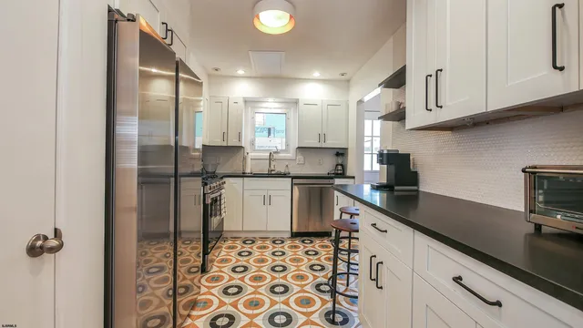a kitchen with a sink a refrigerator and cabinets