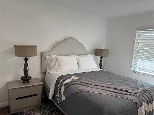 a bed sitting in a bedroom next to a window