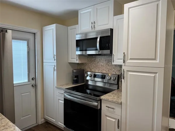 a kitchen with stainless steel appliances a stove microwave and sink