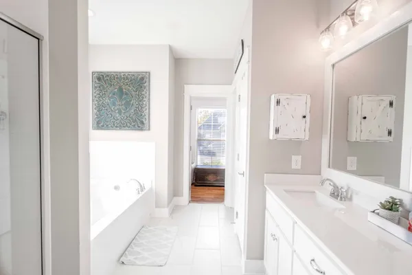 a bathroom with a tub sink and mirror