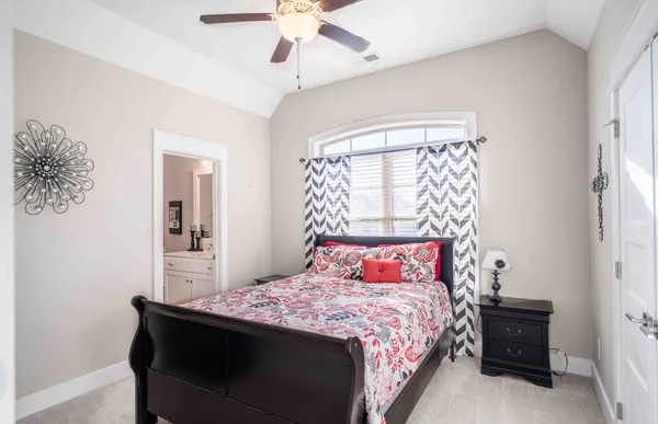 a bedroom with a large bed and a chandelier