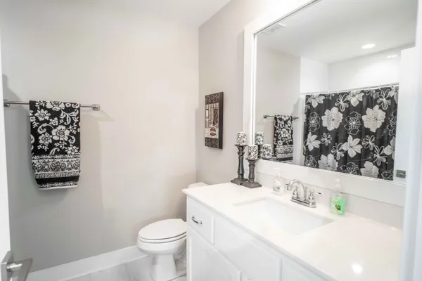a bathroom with a sink a toilet and a large mirror
