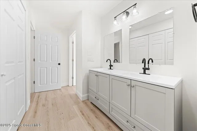 a spacious bathroom with a sink a mirror and shower