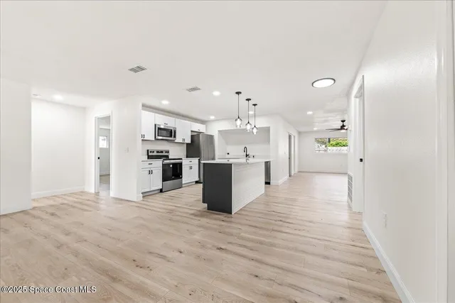 a view of kitchen dining table kitchen island a sink with wooden floor