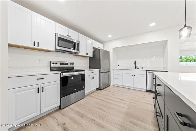a kitchen with stainless steel appliances cabinets a sink and a stove