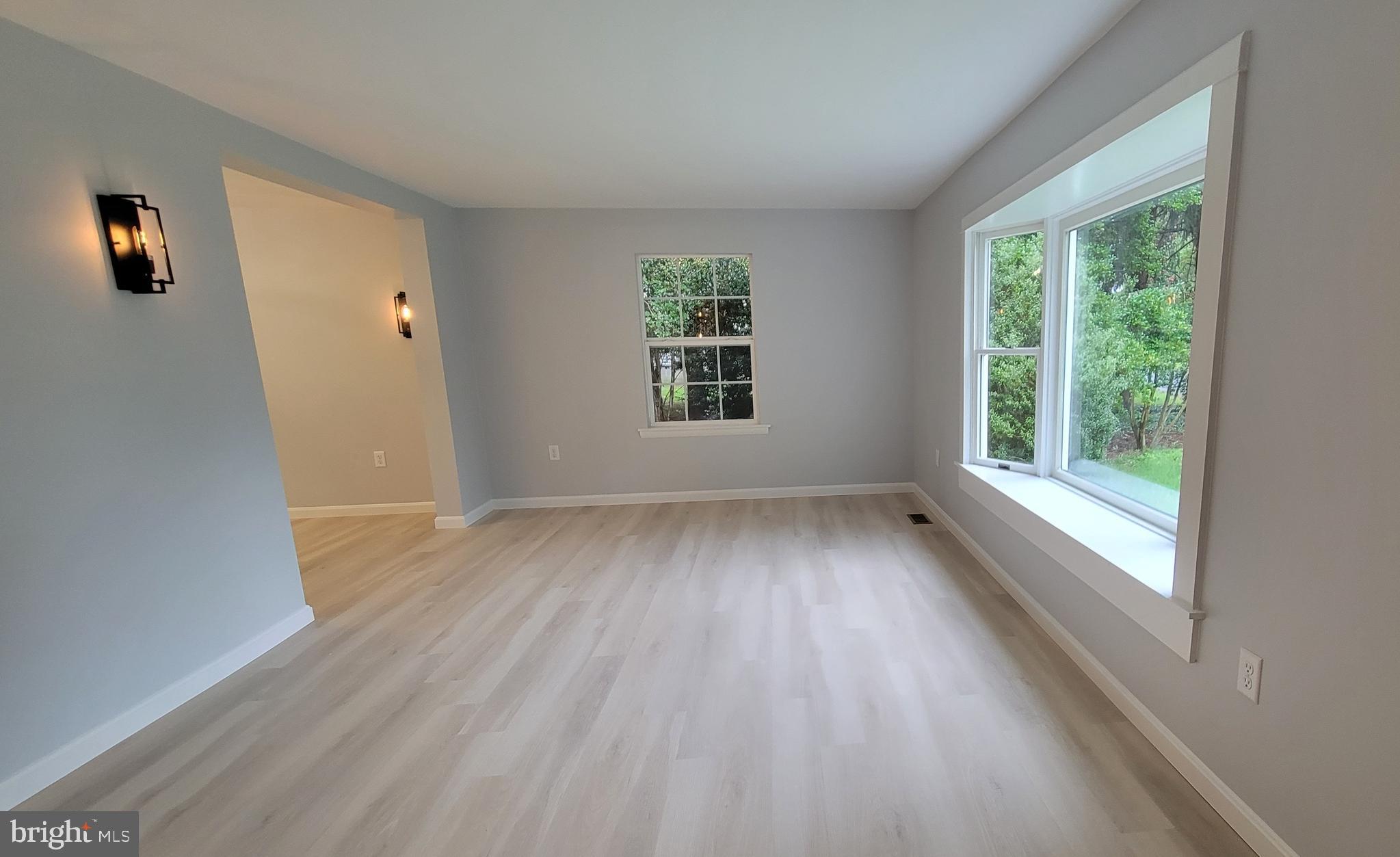 410 Spruce Street Milton, DE 19968 - Photo 3 of 8 an empty room with wooden floor and windows