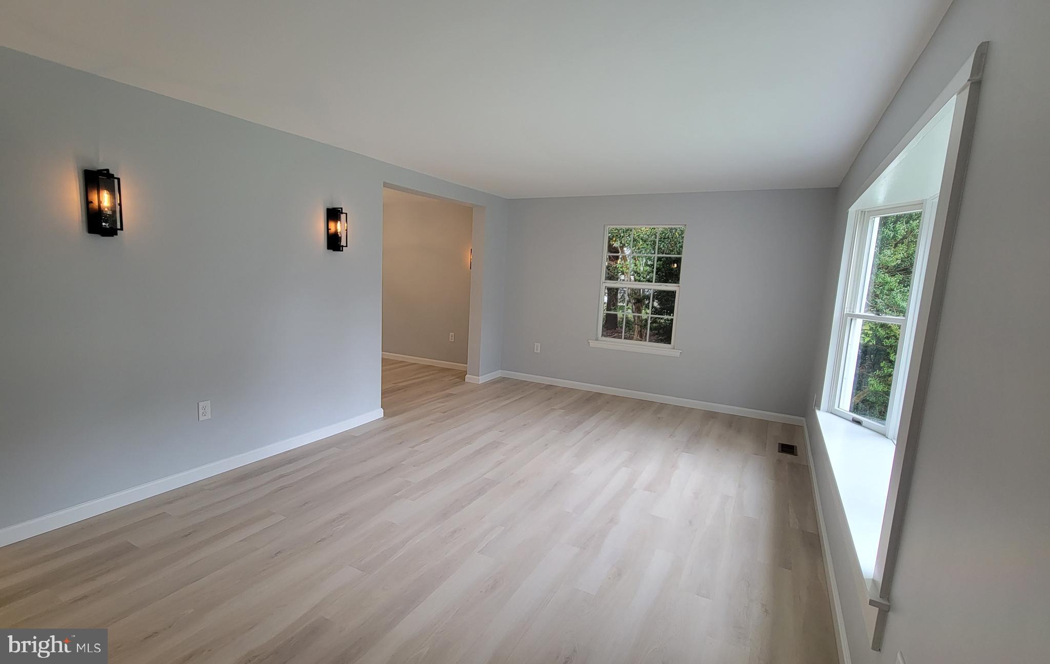 410 Spruce Street Milton, DE 19968 - Photo 6 of 8 an empty room with wooden floor and windows