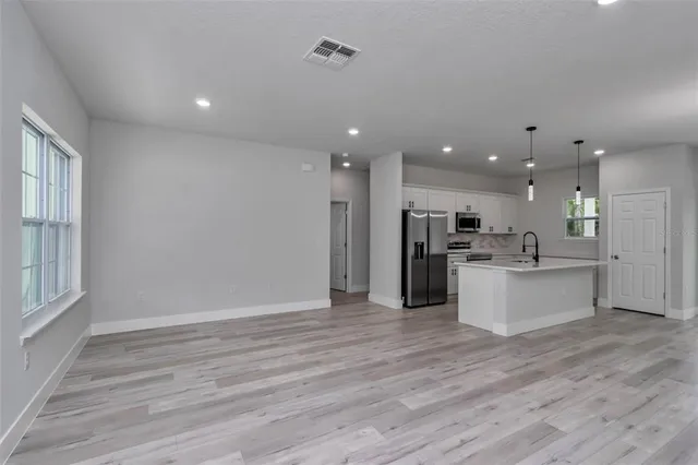 a view of kitchen with kitchen island wooden floors stainless steel appliances