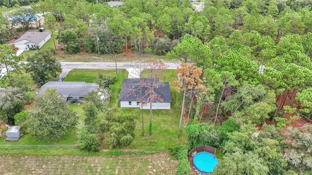 an aerial view of a house with a yard and lake view