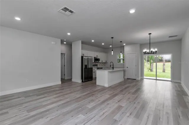 a view of a kitchen with a refrigerator and a wooden floor