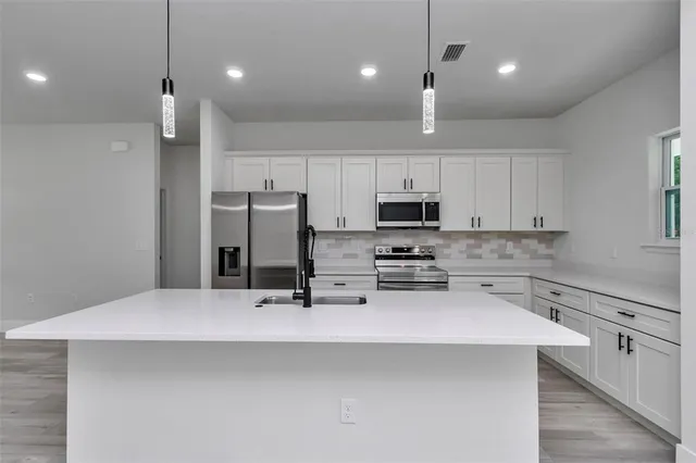 a kitchen with stainless steel appliances a refrigerator sink and microwave