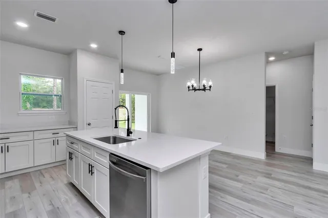 a kitchen with a sink stove and wooden floor