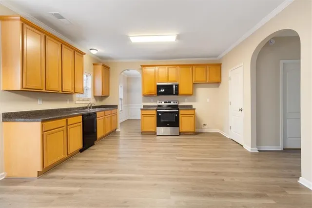 a kitchen with stainless steel appliances granite countertop a stove top oven and sink