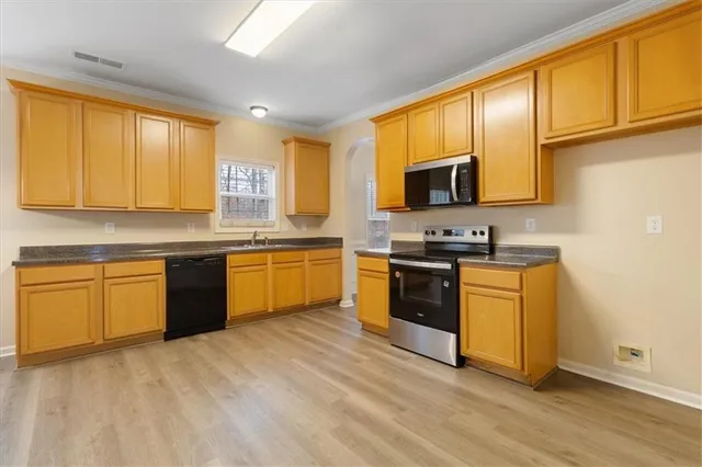 a kitchen with stainless steel appliances granite countertop a stove a sink and a microwave