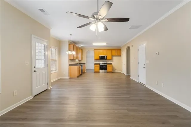 a view of an empty room and kitchen view