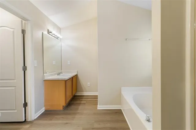 a bathroom with a tub sink and mirror