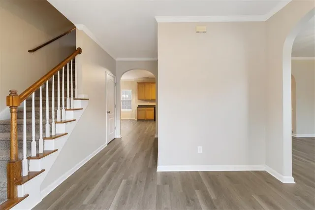 a view of a hallway with wooden floor and staircase