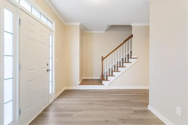 a view of entryway and hall with wooden floor