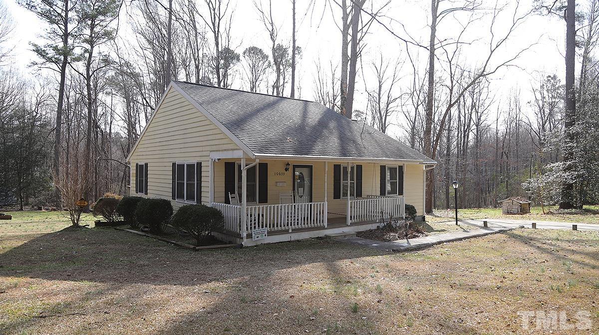a front view of a house with a yard covered with snow and trees
