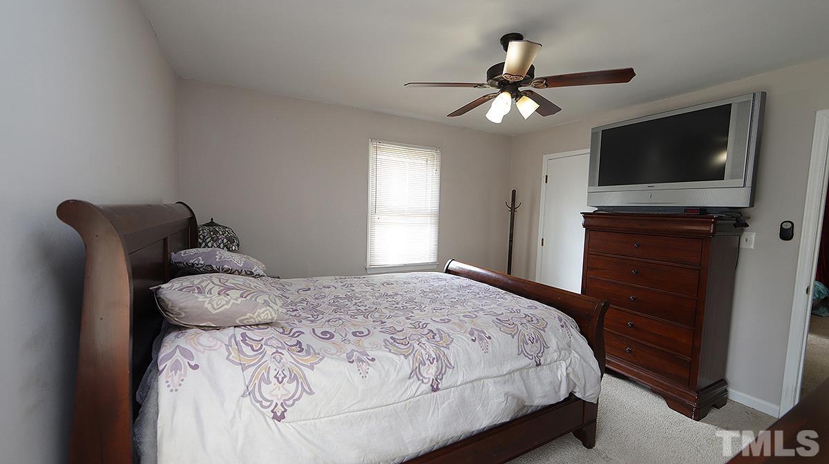 10633 Old Stage Road Raleigh, NC 27603 - Photo 10 of 20 a bedroom with a bed and a flat screen tv